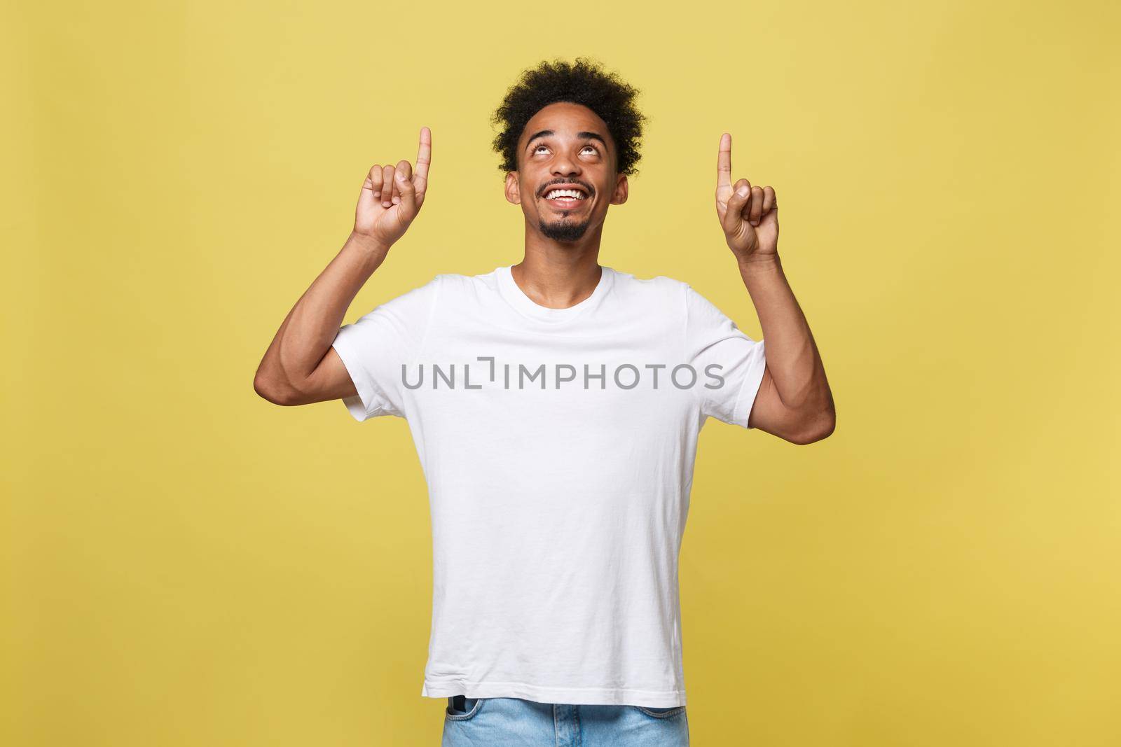 Young handsome african american man over yellow background pointing upwards. by Benzoix