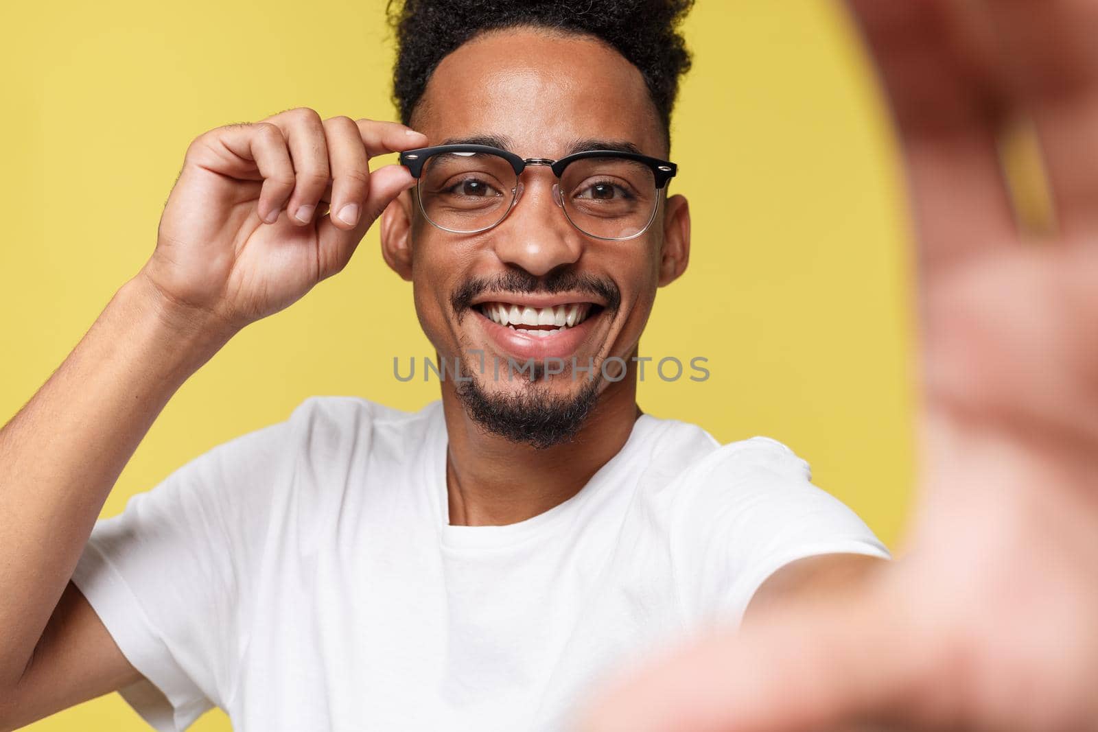 Close up portrait of excited cheerful glad with toothy smile dressed in white tshirt isolated on yellow background.