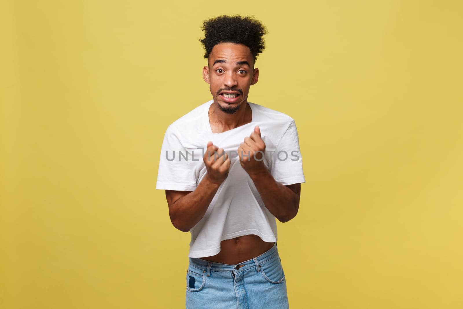 Portrait of angry or annoyed young African American man in white shirt looking at the camera with displeased expression. Negative human expressions, emotions, feelings. Body language. by Benzoix