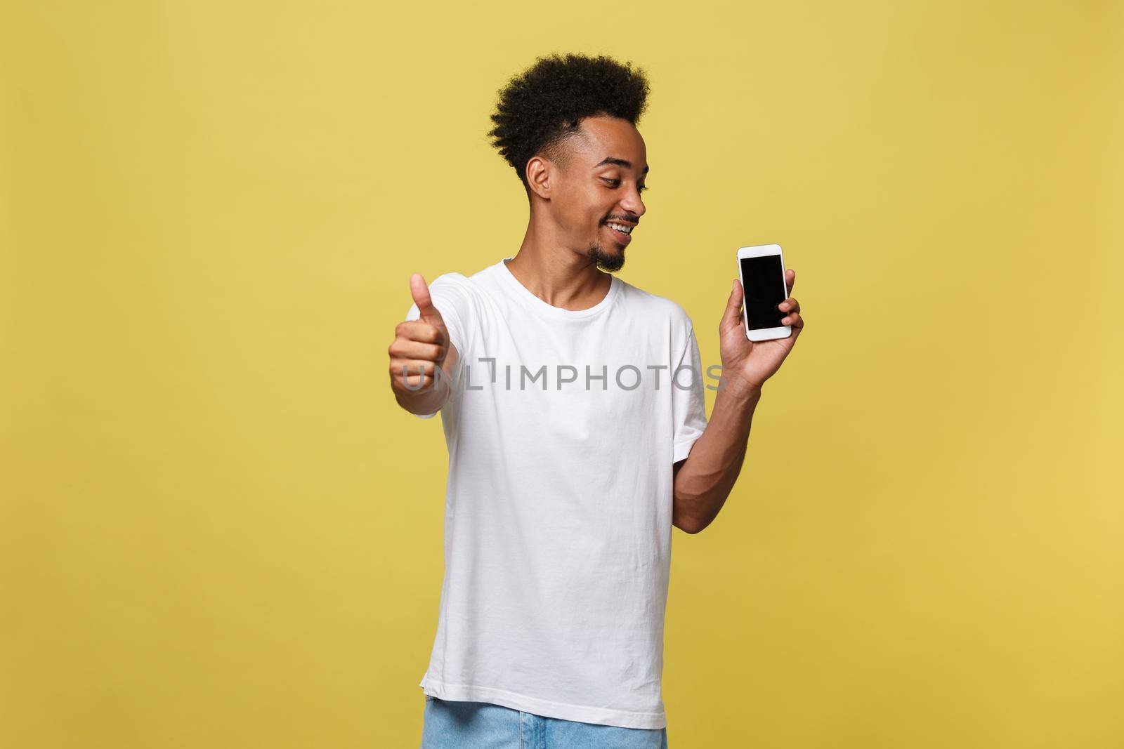 Portrait of cheerful african american man talking on cellphone with thumbs up hand sign.