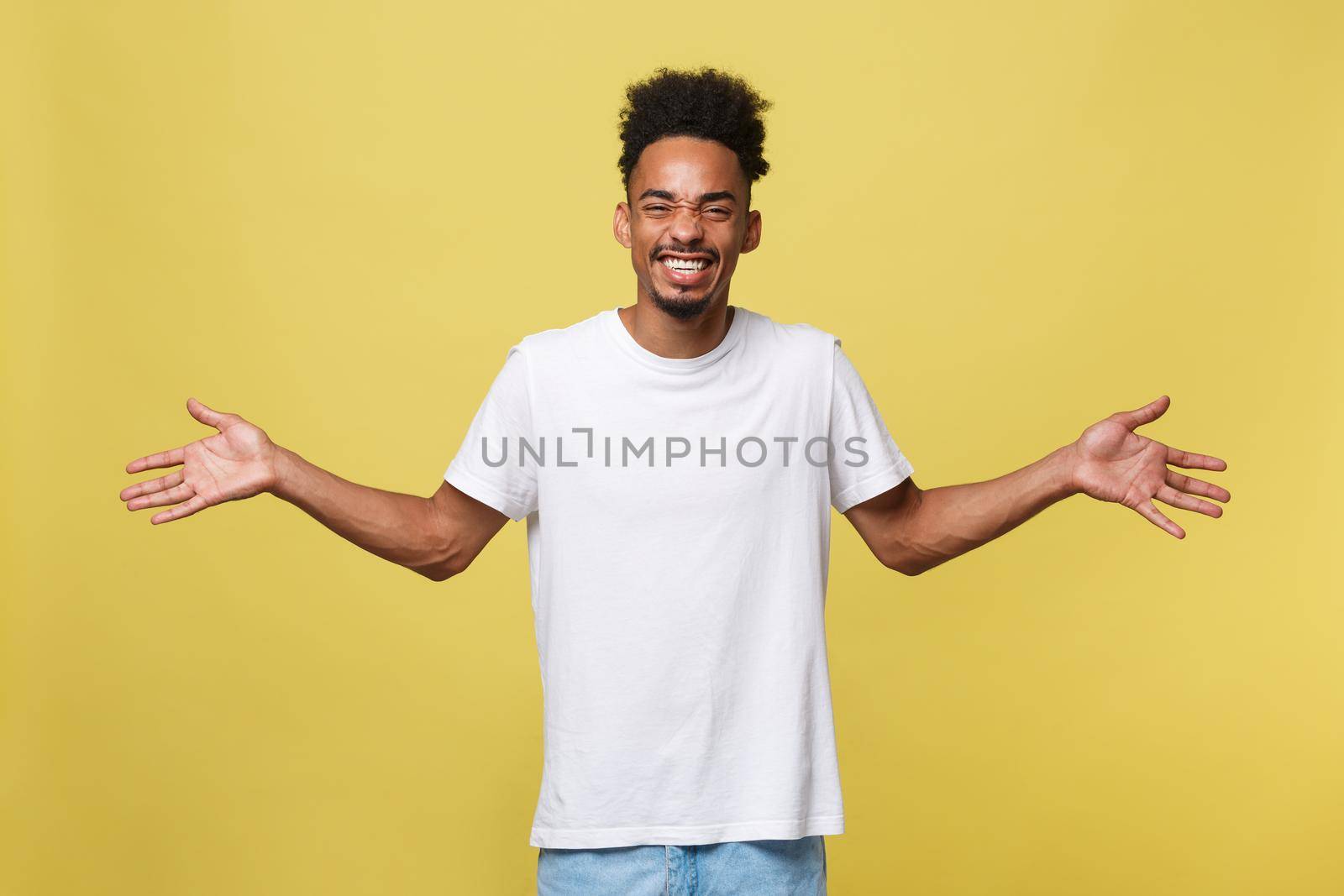 Advertising concept. Portrait of handsome African entrepreneur or office worker wearing suit pointing his finger at yellow studio wall with copy space for your content, looking shocked and surprised