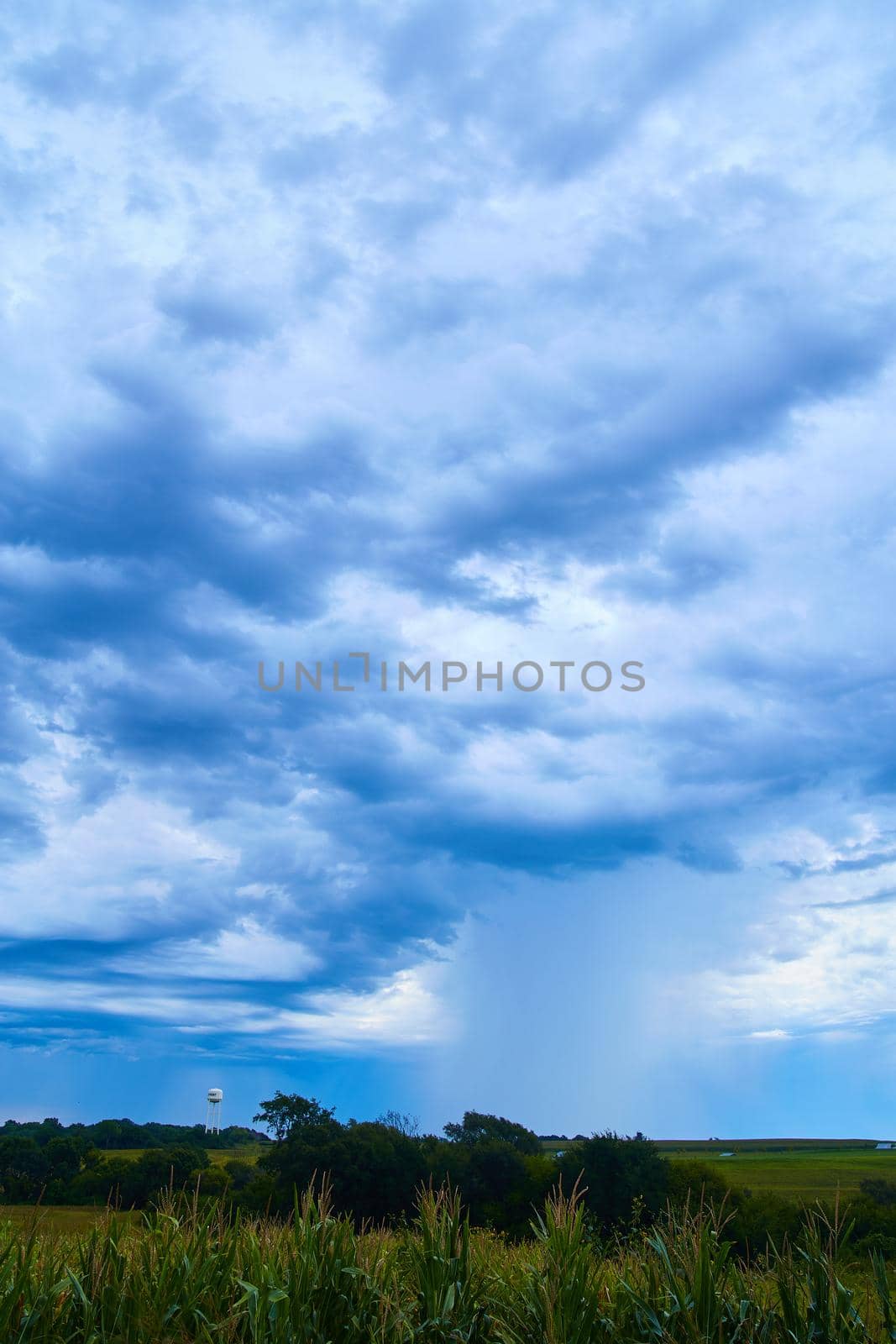 Image of Corn fields and water tower in dark ominous clouds