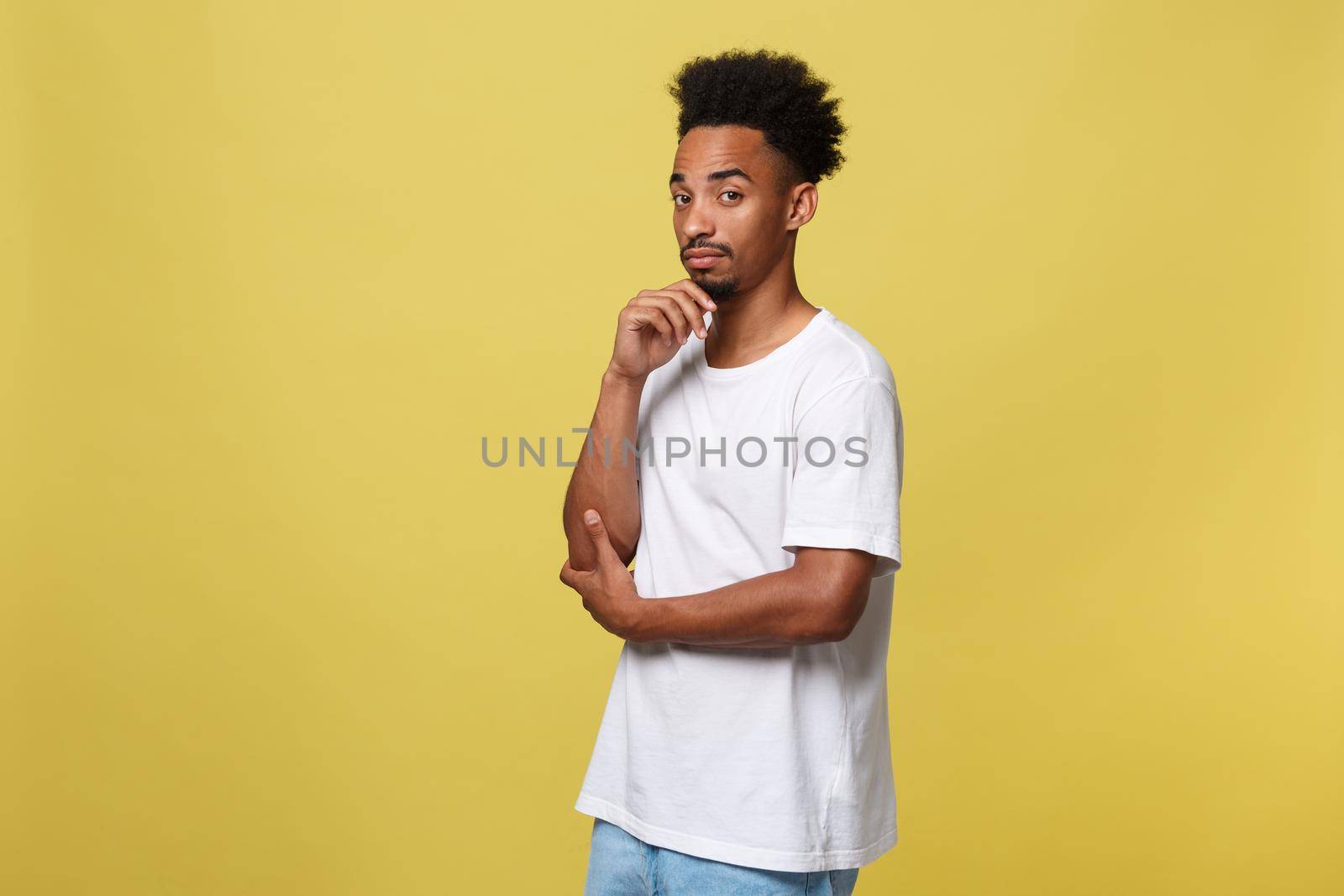 Handsome African-American teenager with casual cloth isolated on yellow background