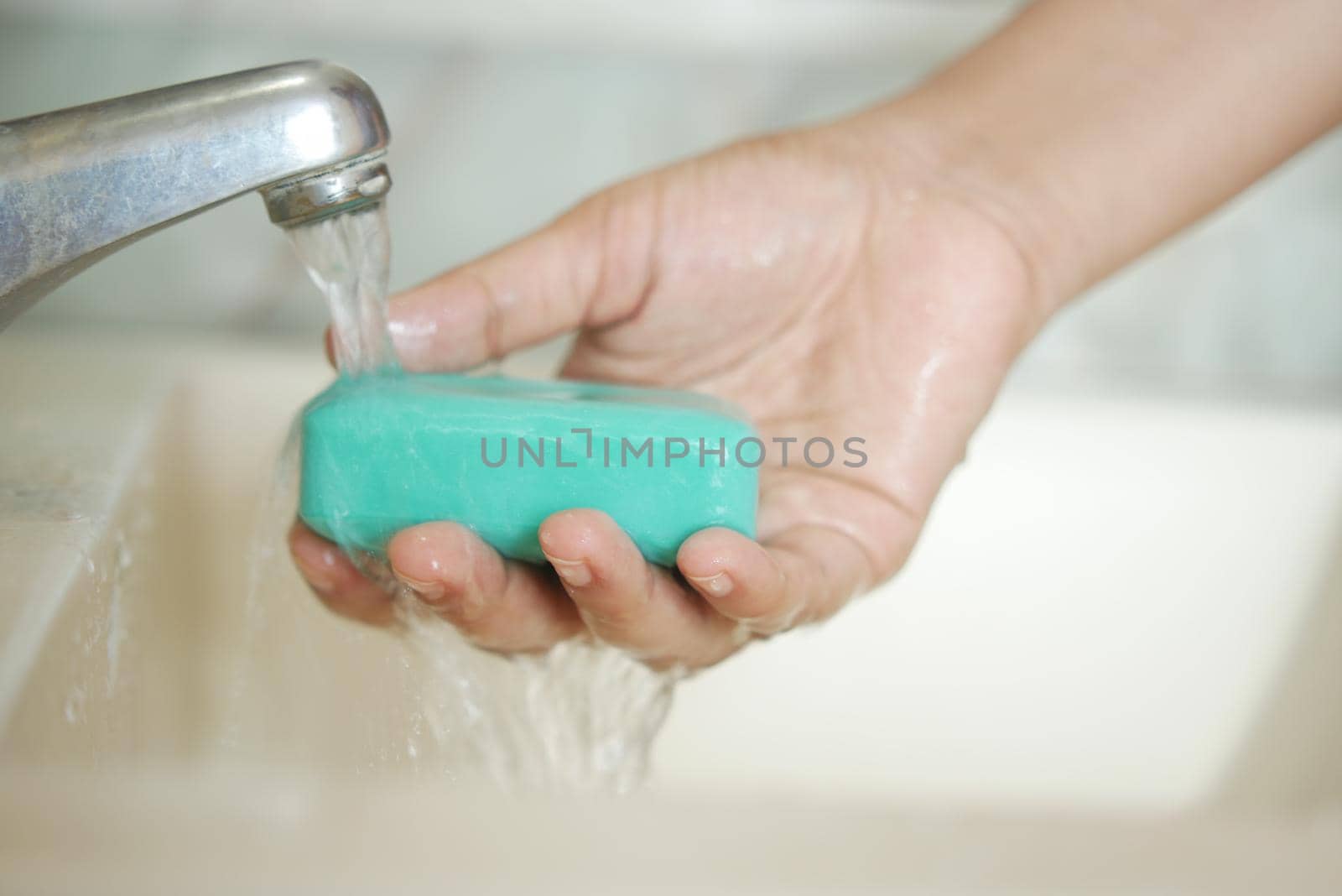 women washing hands with soap warm water .