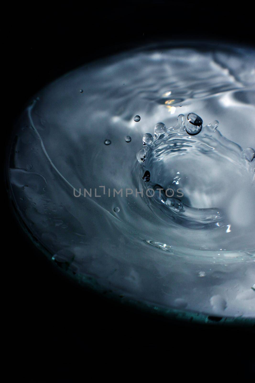 Image of Water splashes in a pool with a black background