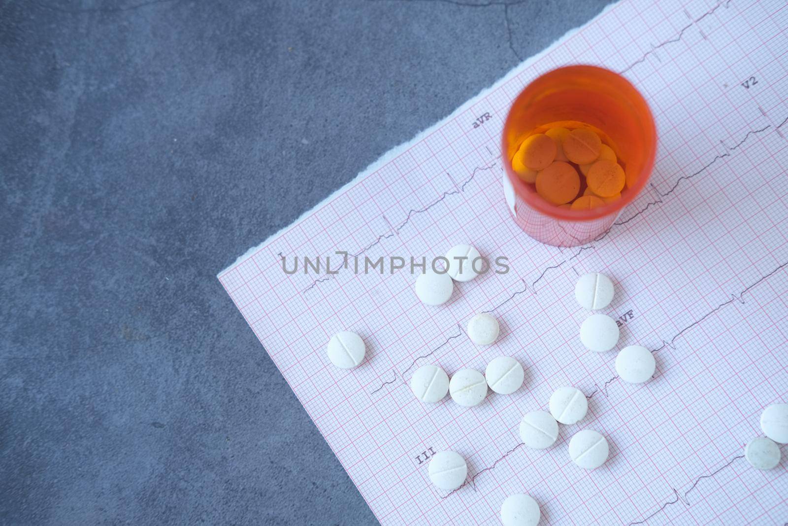 medical pills and container on a cardio diagram