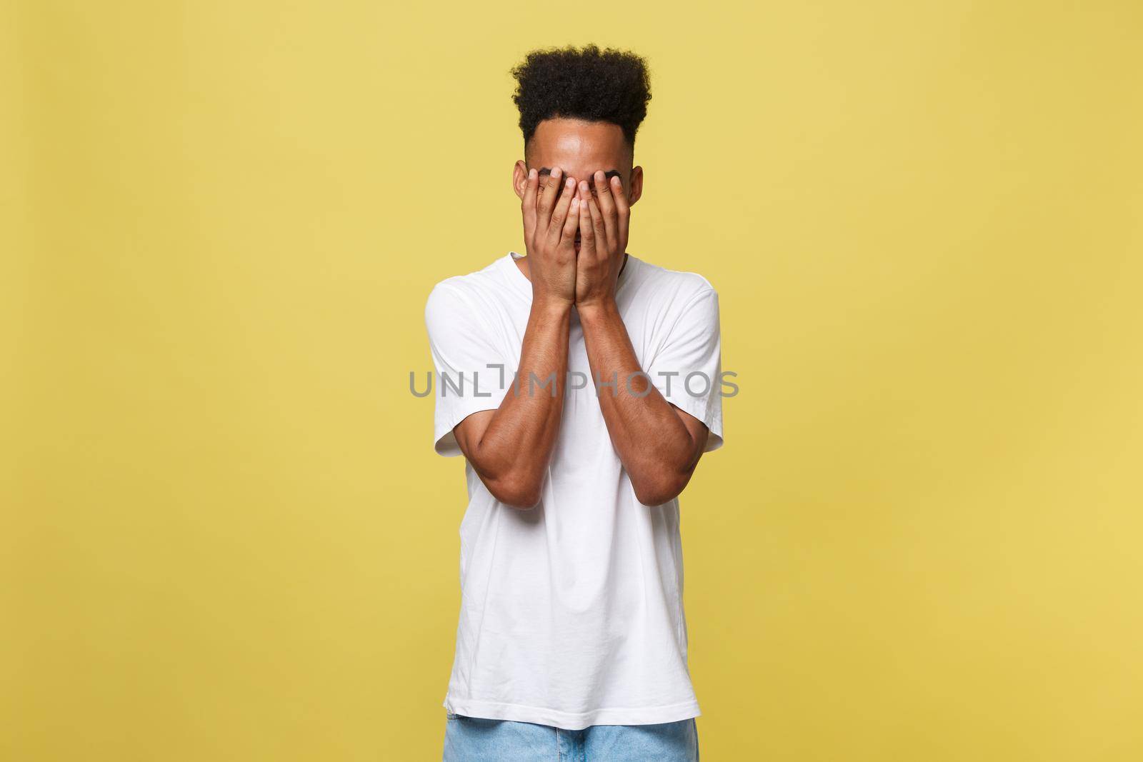 Closeup portrait man with sad expression, isolated on yellow wall background. Human emotions, body language, life perception. Duh moment. by Benzoix