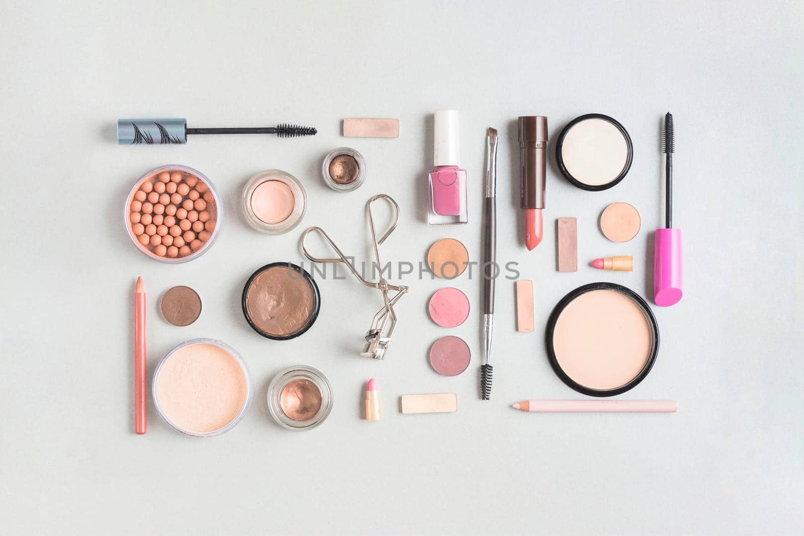 makeup products arranged rectangular shape white backdrop. High resolution photo