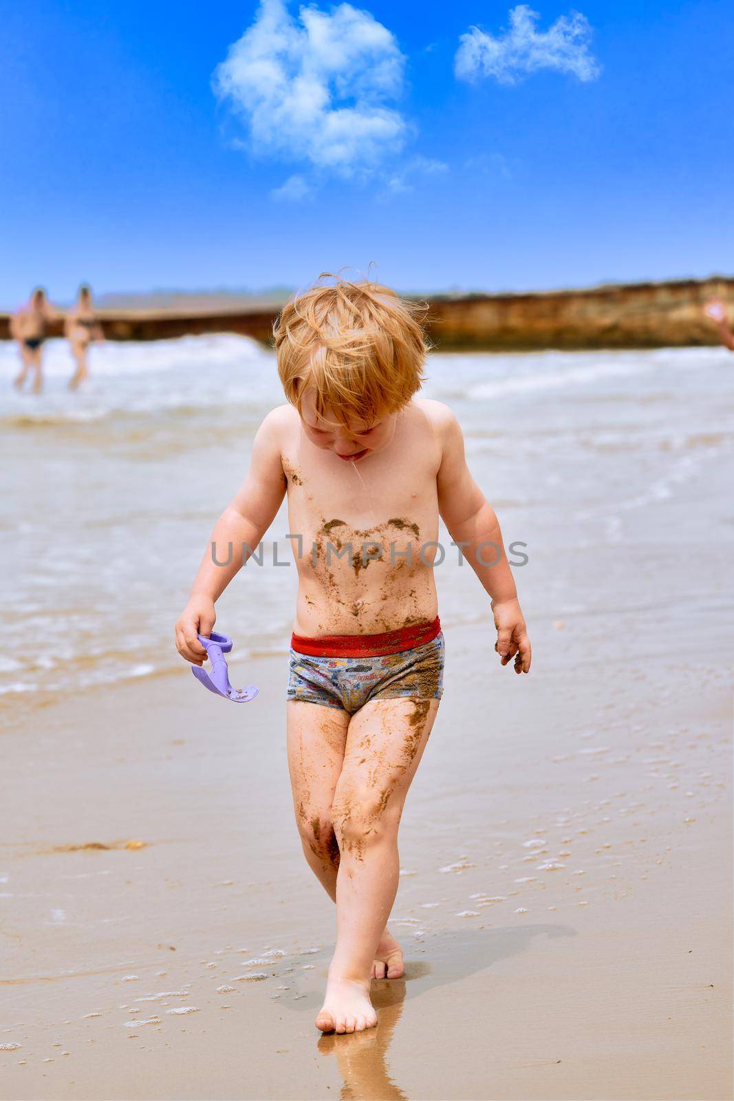 A little boy gets dirty in mud and walks crying along the beach by vizland