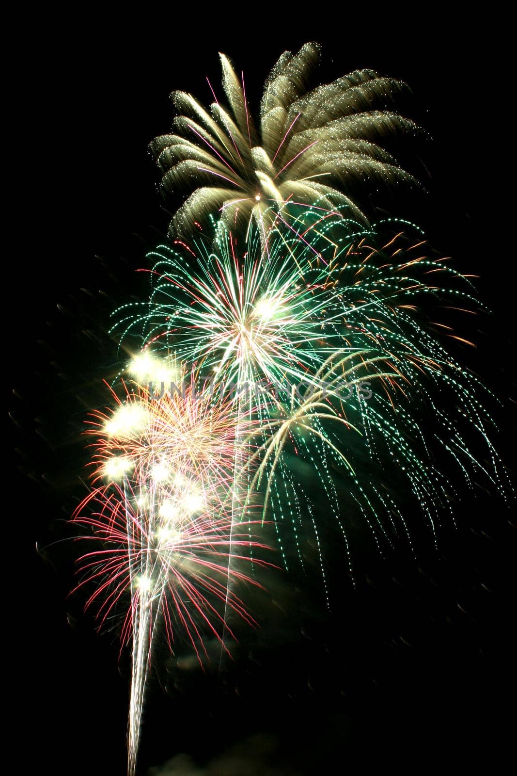 Multicolored Fourth of July fireworks at night that are green and yellow and red and white by njproductions