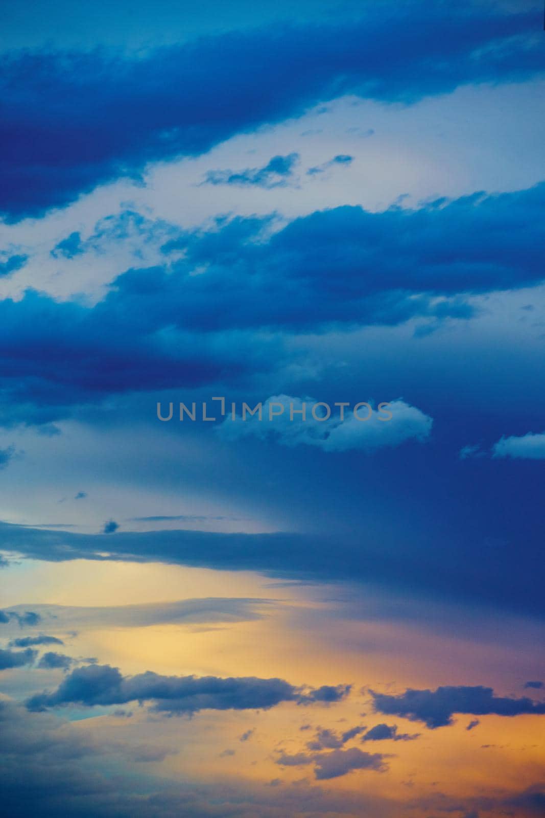 Image of Vertical clouds sunset sunrise with blue and gold color