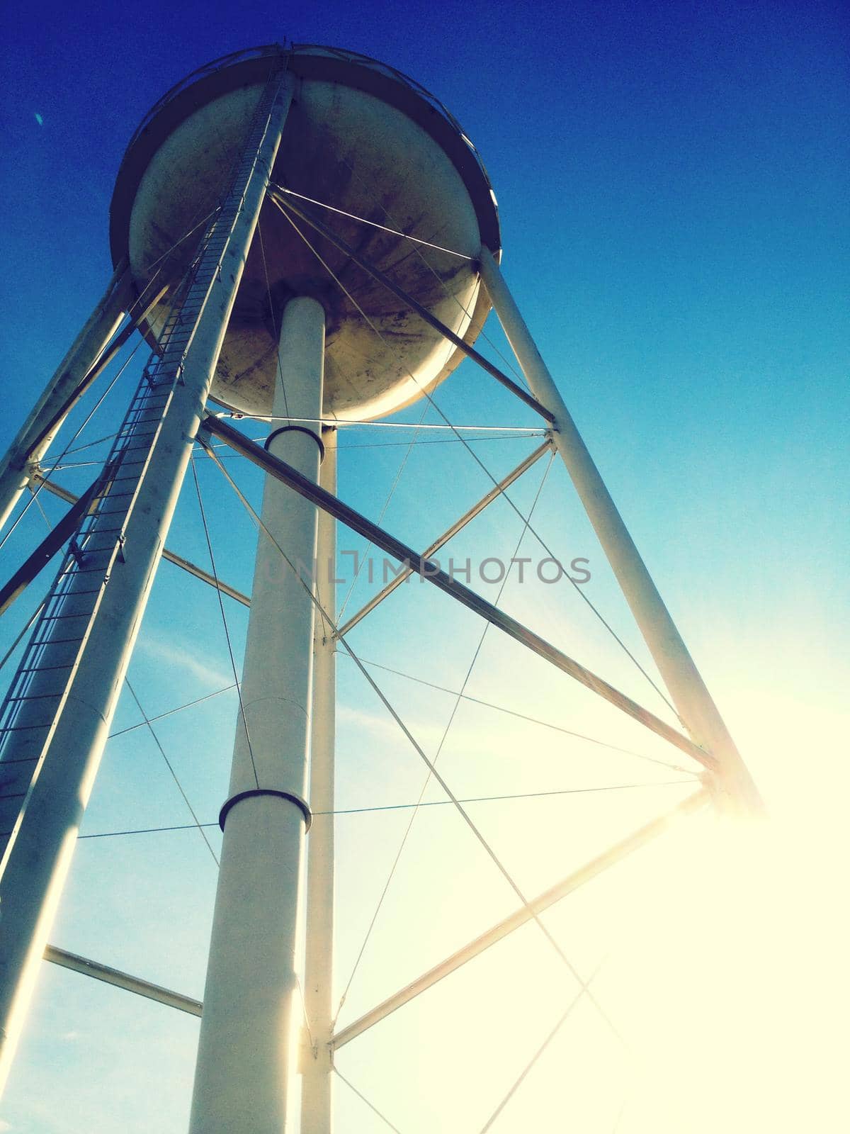 Image of Worm's eye view of a water tower against a blue sky