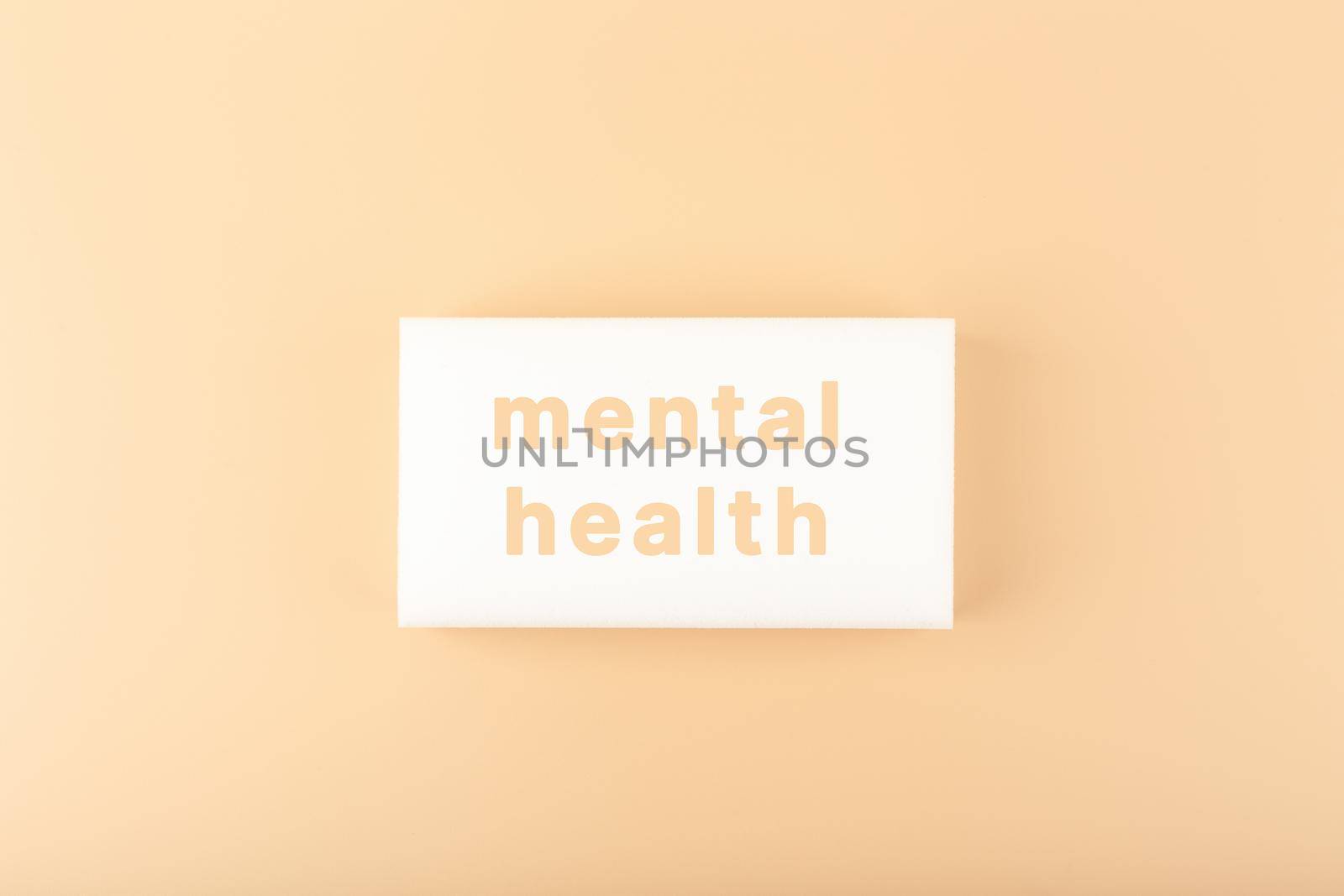 Creative minimal flat lay with white tablet with written mental health text on bright beige background. Concept of world mental health day, mental health assessment and awareness