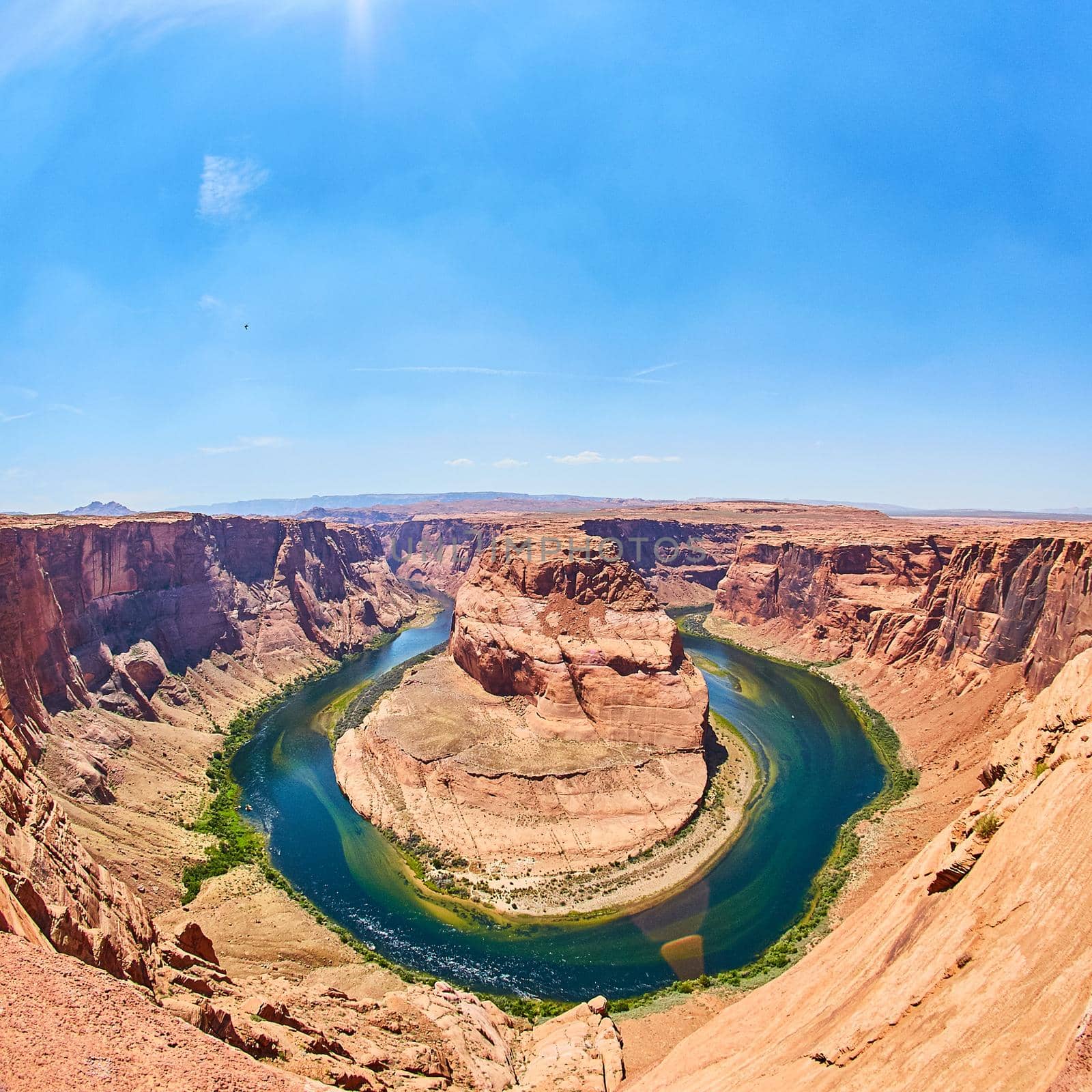 Aerial shot of a canyon surrounding a large river or pond shaped around a rocky outcropping Horseshoe Bend by njproductions