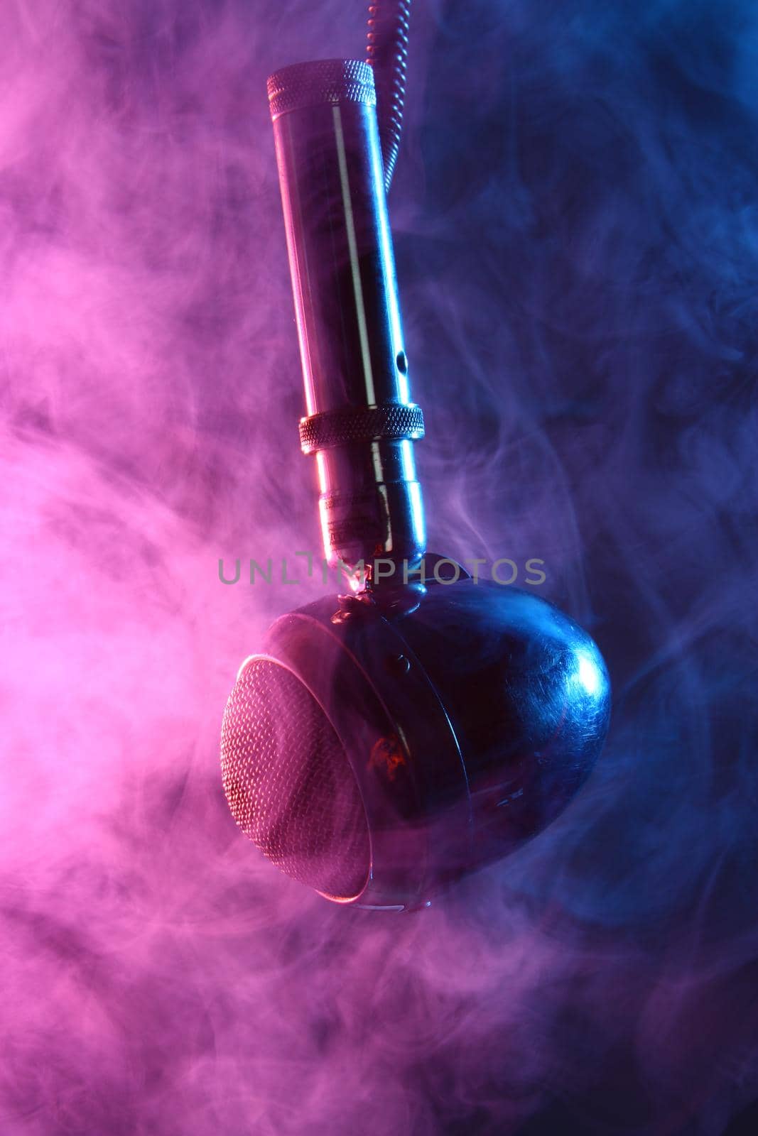 Image of Old egg-shaped microphone surrounded by blue and pink smoke