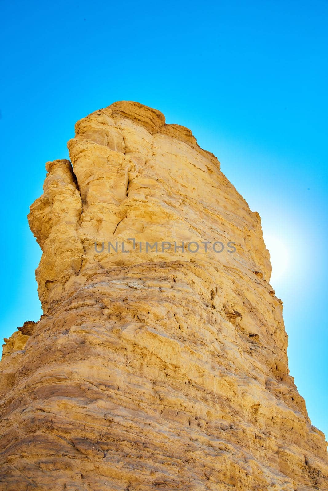 Image of Pillar of white stone blocking sun with vibrant blue sky