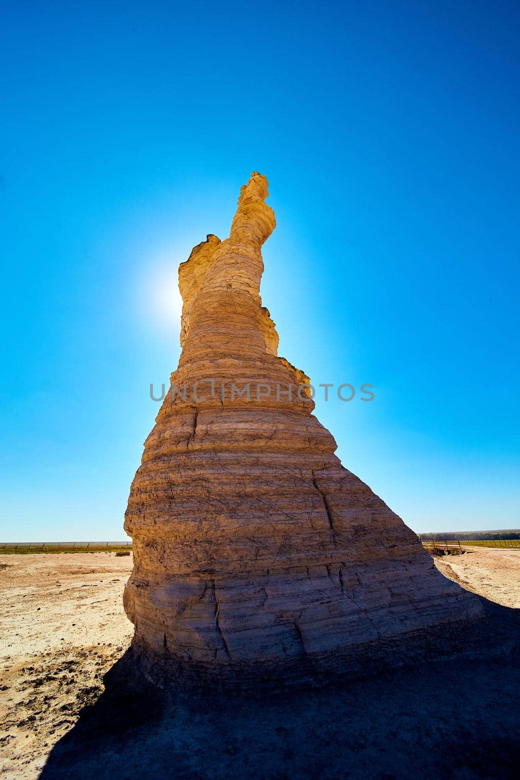 Image of Pillar of white rock blocking sun in desert against blue sky