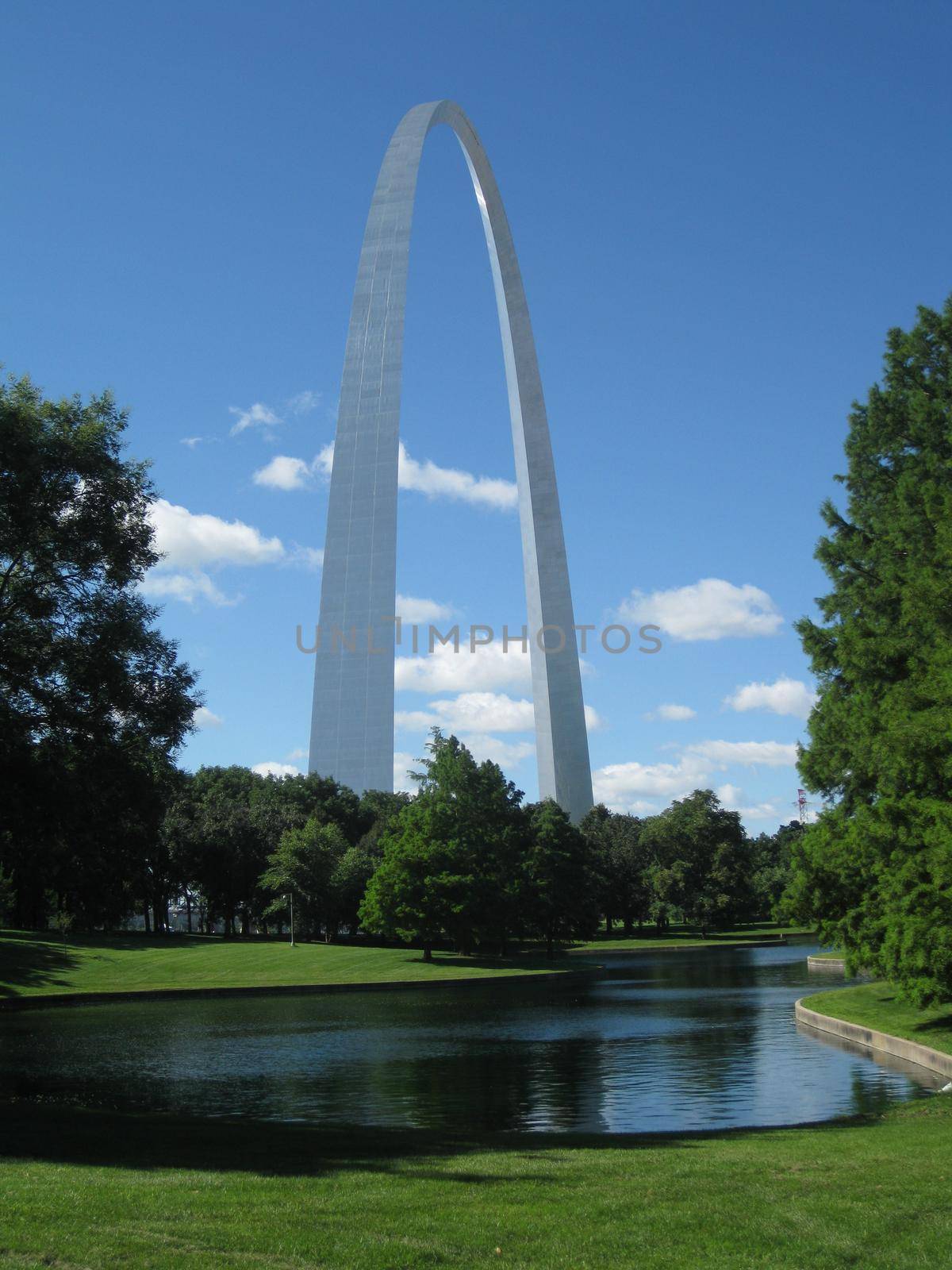 The St Louis Arch with a pool and trees at its base by njproductions