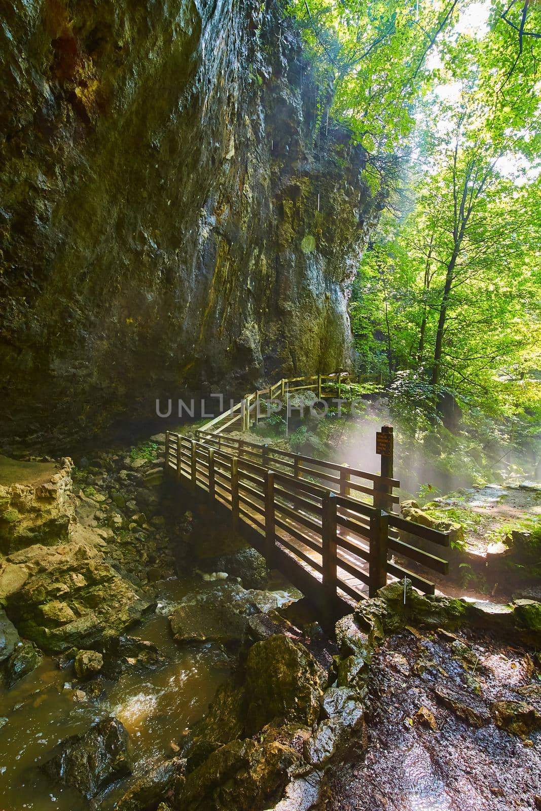 Image of Walking bridge against cliff edge and over creek
