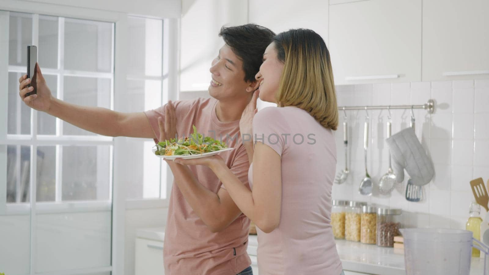 woman and man using smartphone live streaming while salad food by Sorapop