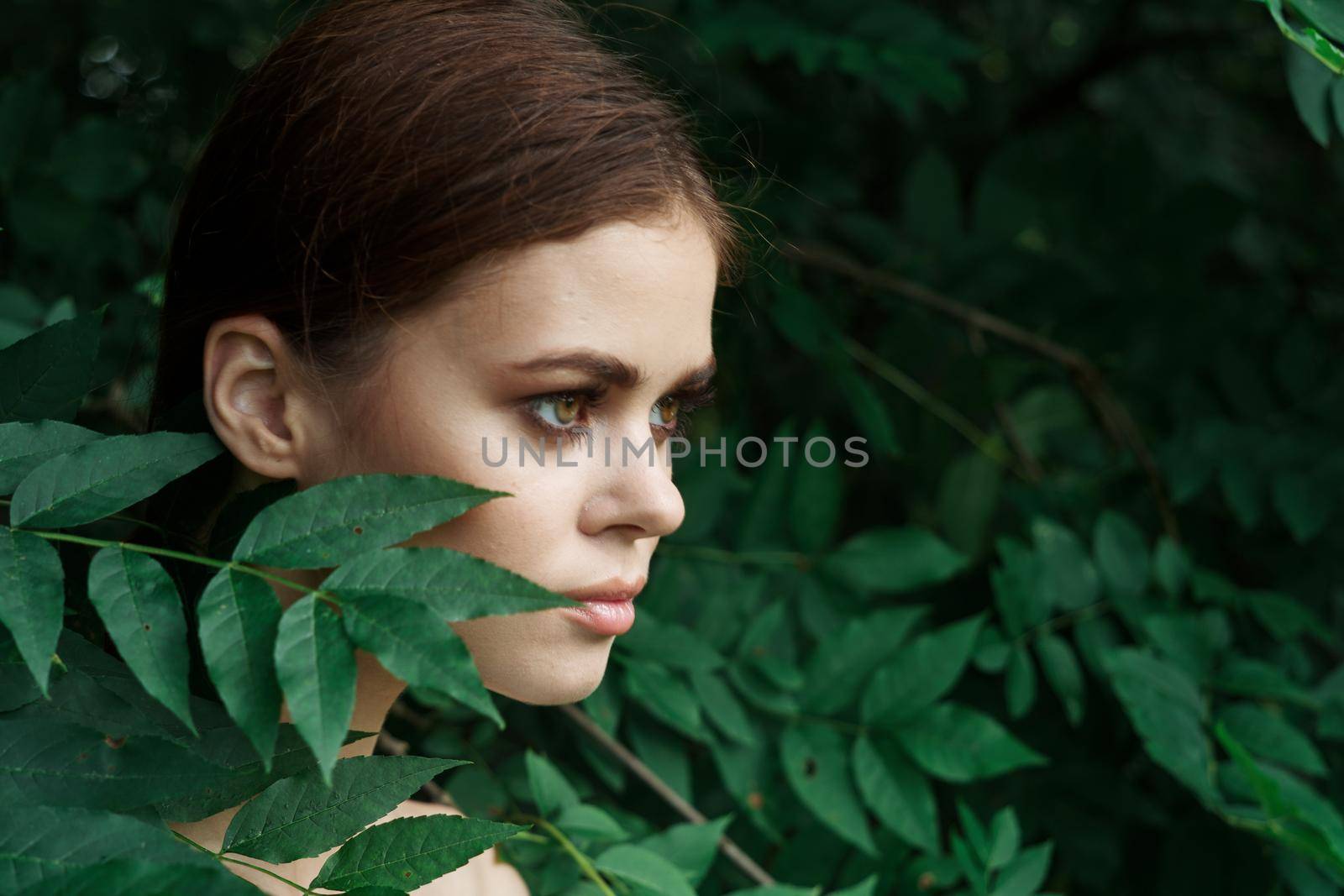 beautiful woman skin care bare shoulders green leaves nature model. High quality photo