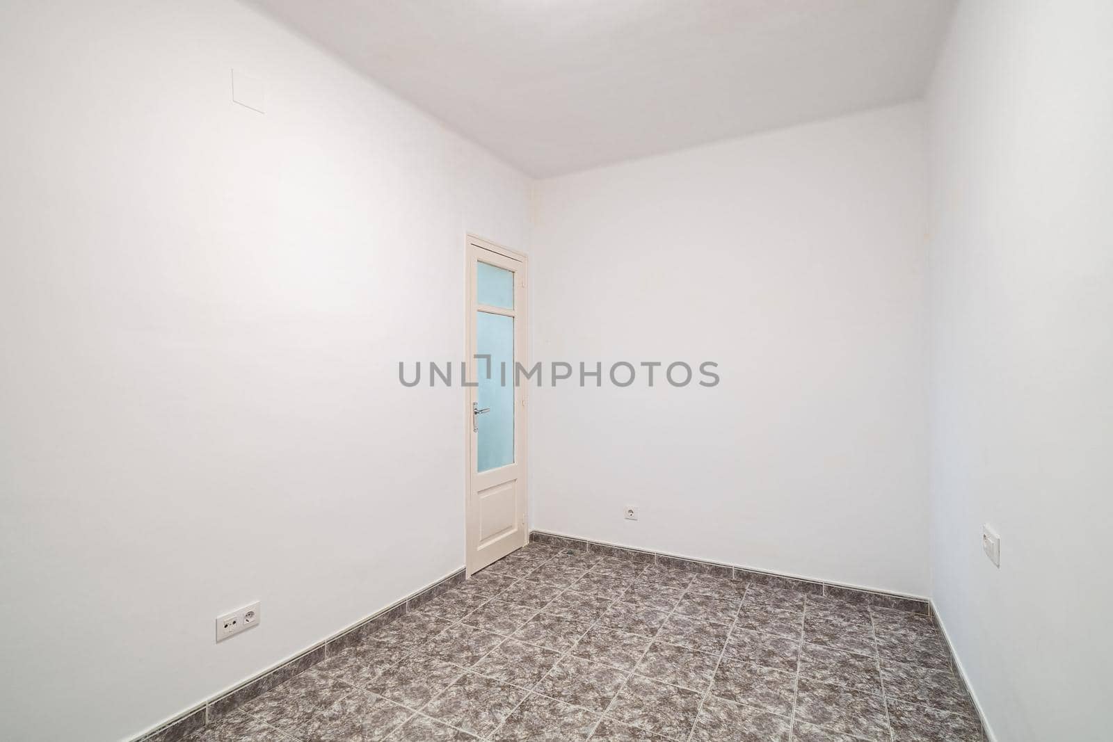Room interior after renovation, unfurnished apartment with white walls, tiled floor and small door