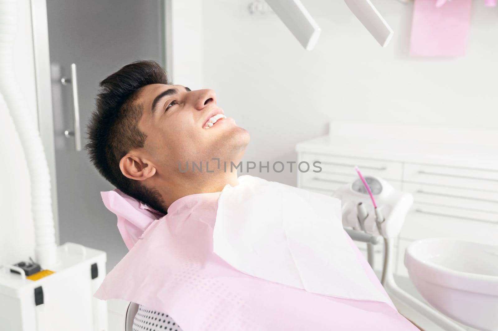 Portrait of happy patient in dental chair. by HERRAEZ