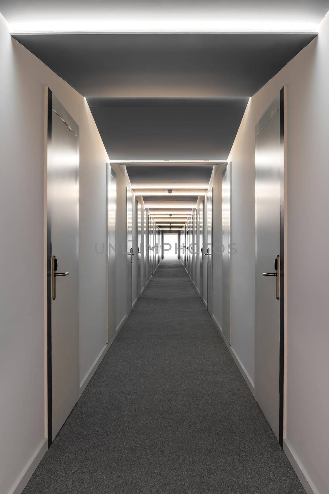 Long corridor in an office or hotel with room doors from both sides.