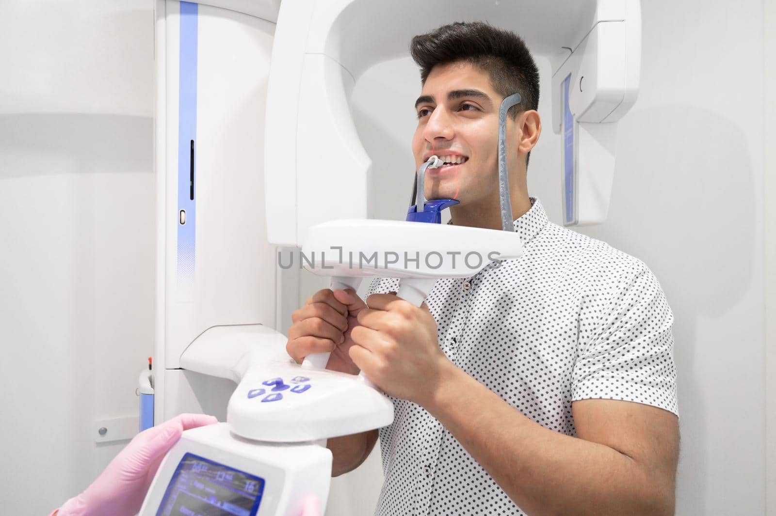 Young man patient standing in x-ray machine. Panoramic radiography. High quality photo.