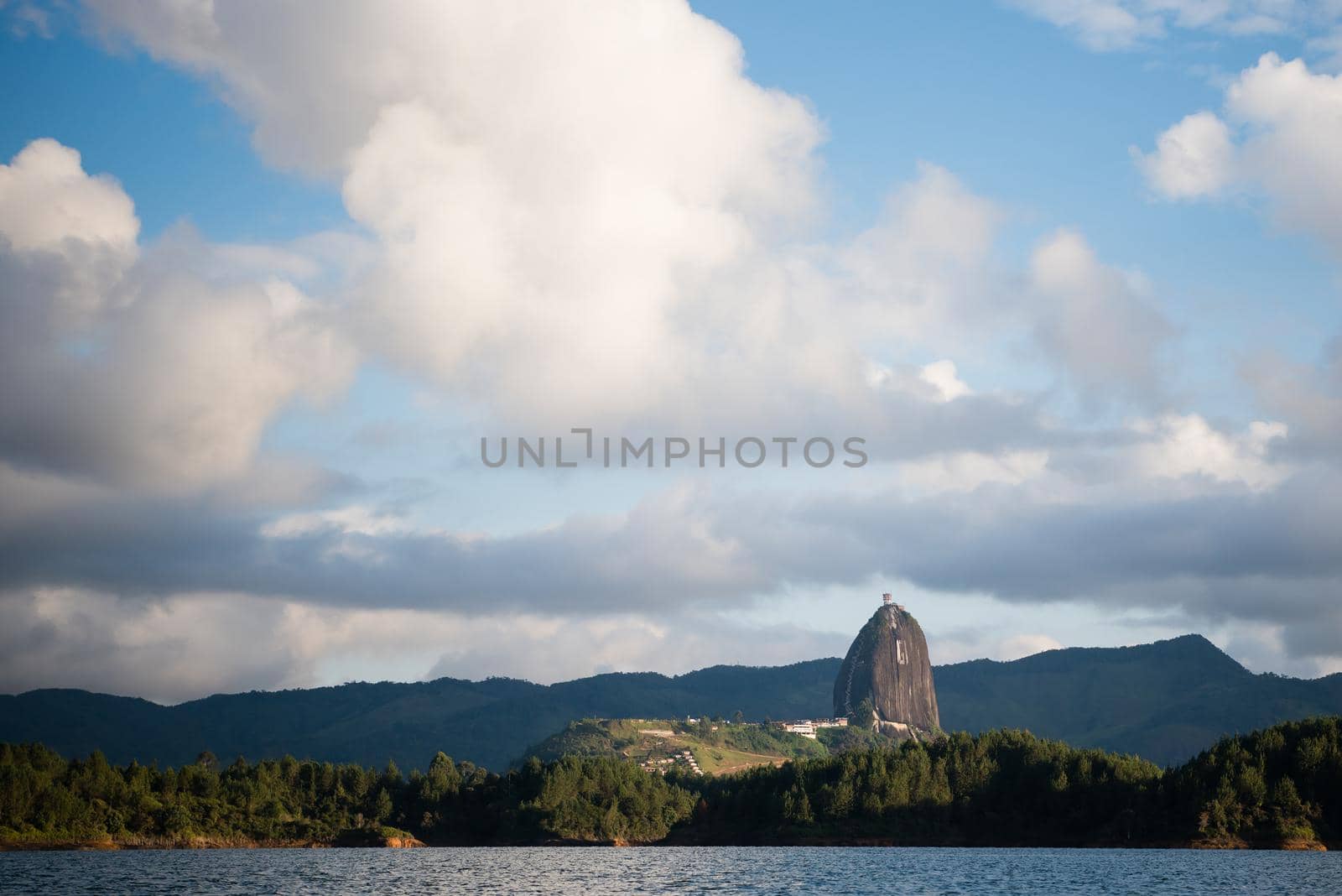 View of El Penon de Guatape in the distance from the water.