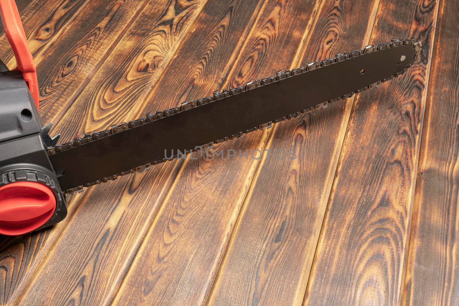 Electric chain saw on wood on a wooden background. Top view by roman112007