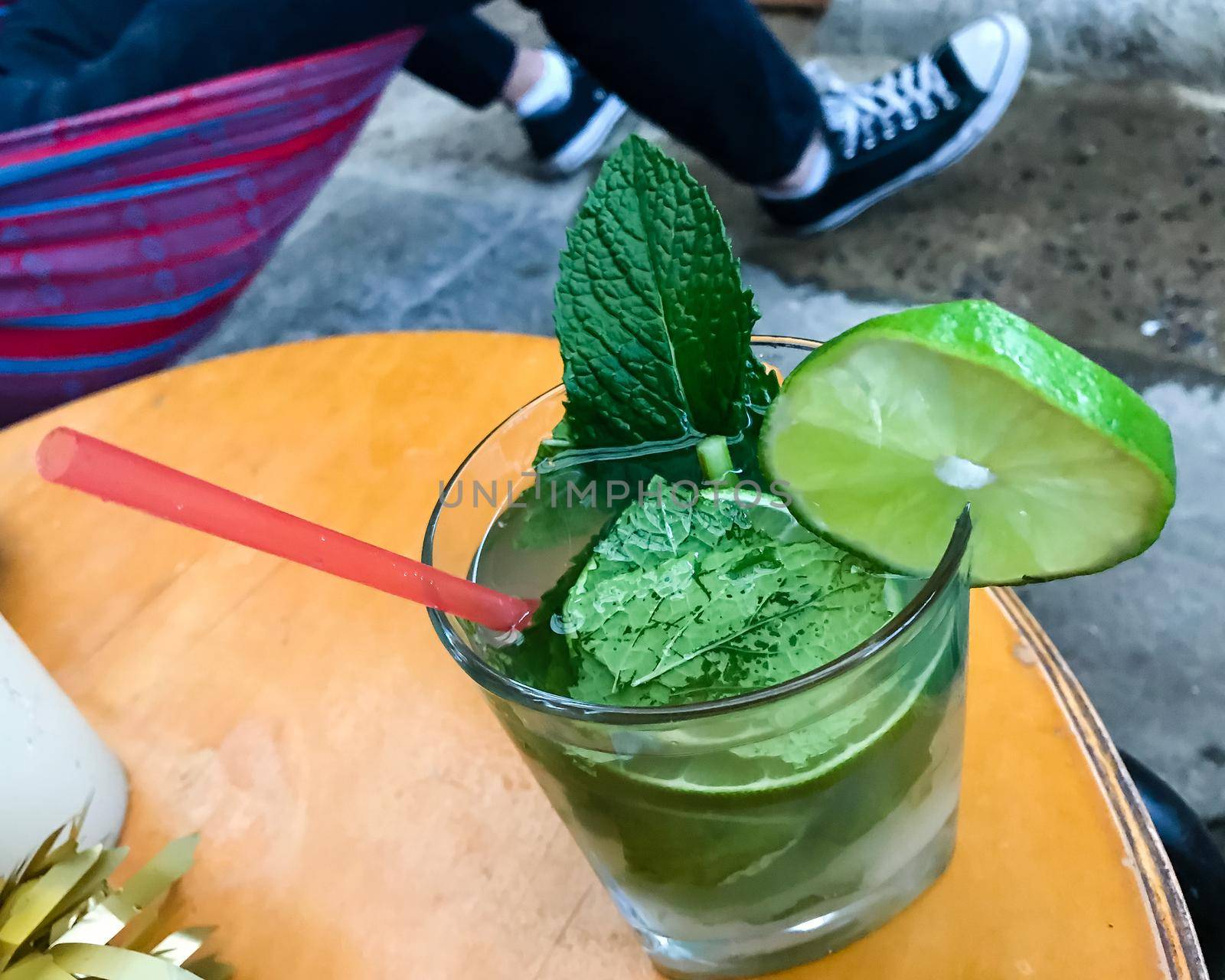 Mojito cocktail with mint leaves and lime with straw. Top view