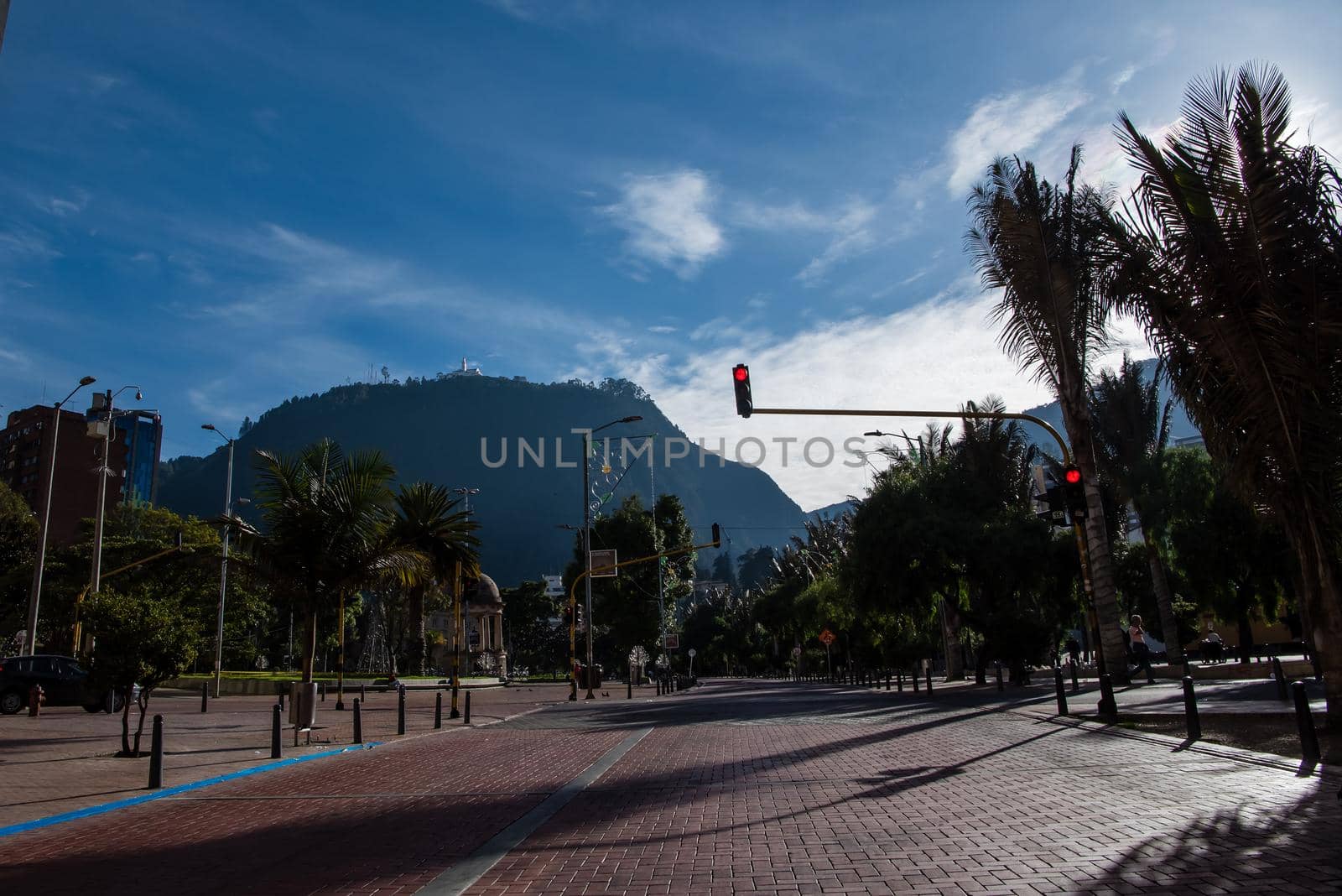 Mount Monserrate from downtown Colombia with traffic light in the foreground. by jyurinko