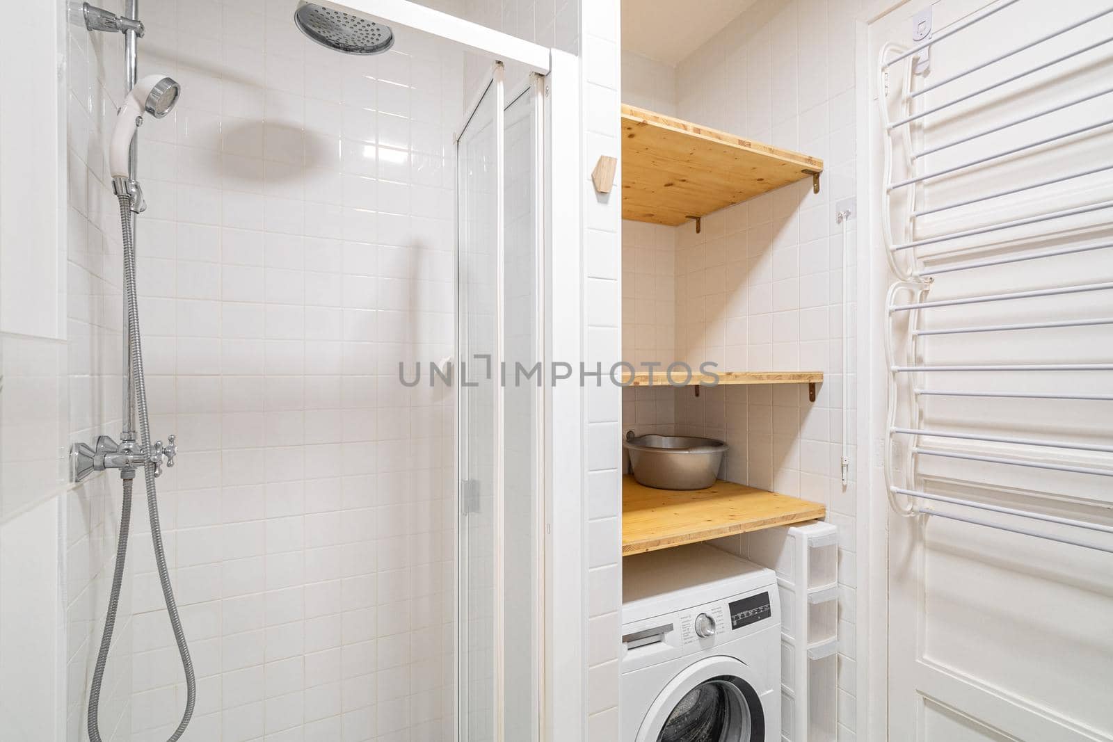 Small bathroom interior with shower and washing machine.