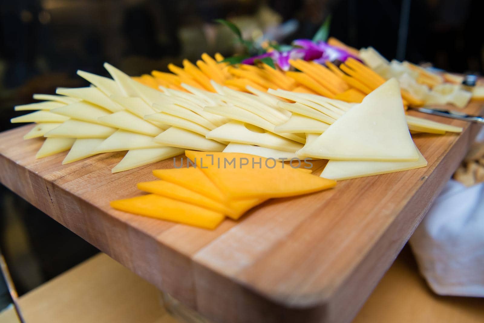 Cheese spread slices laid out on wood tray. by jyurinko