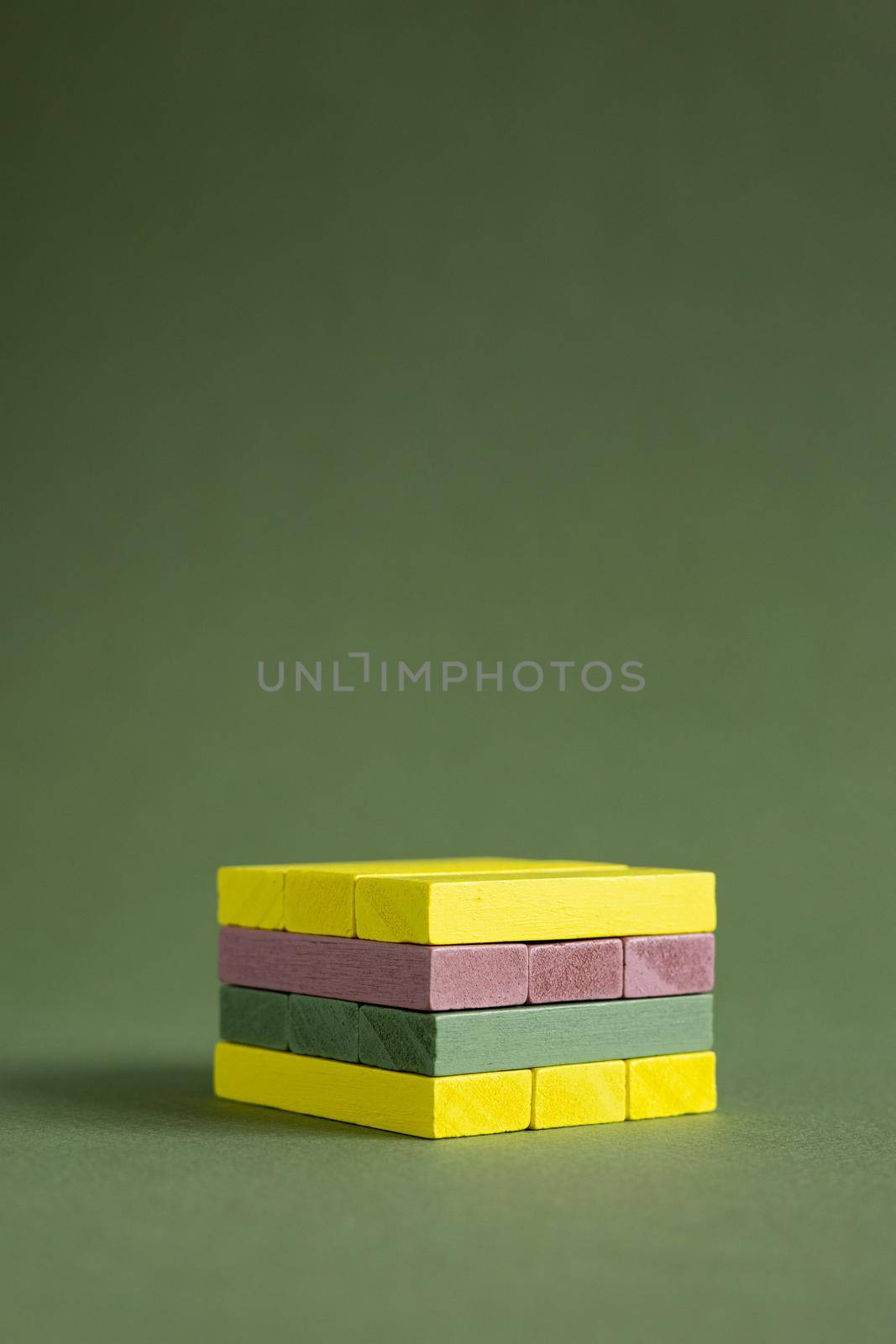 Jenga wood colourful green and yellow on green background copy space, platform for product copy space