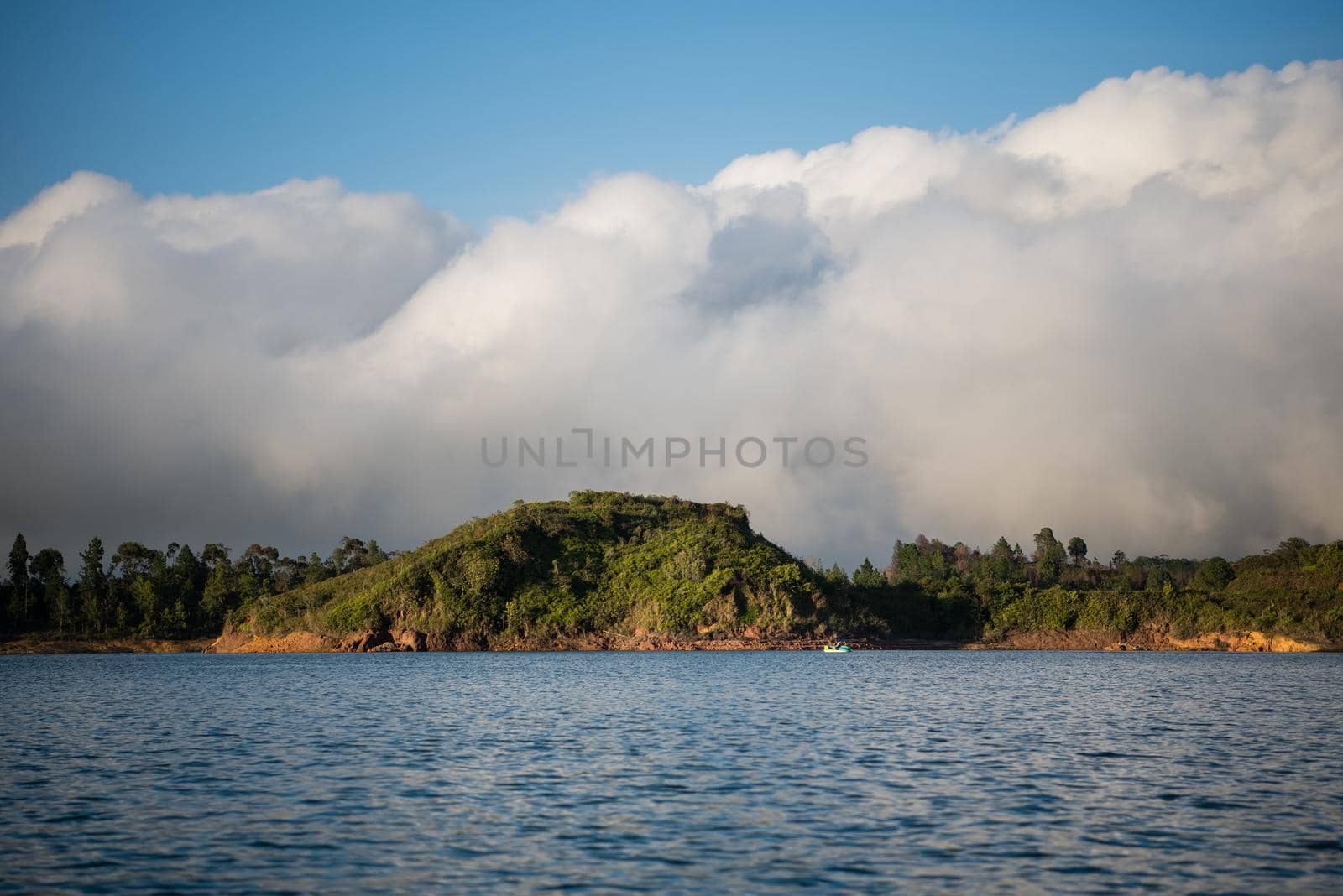 On a boat of a big cloud sitting behind an island. by jyurinko