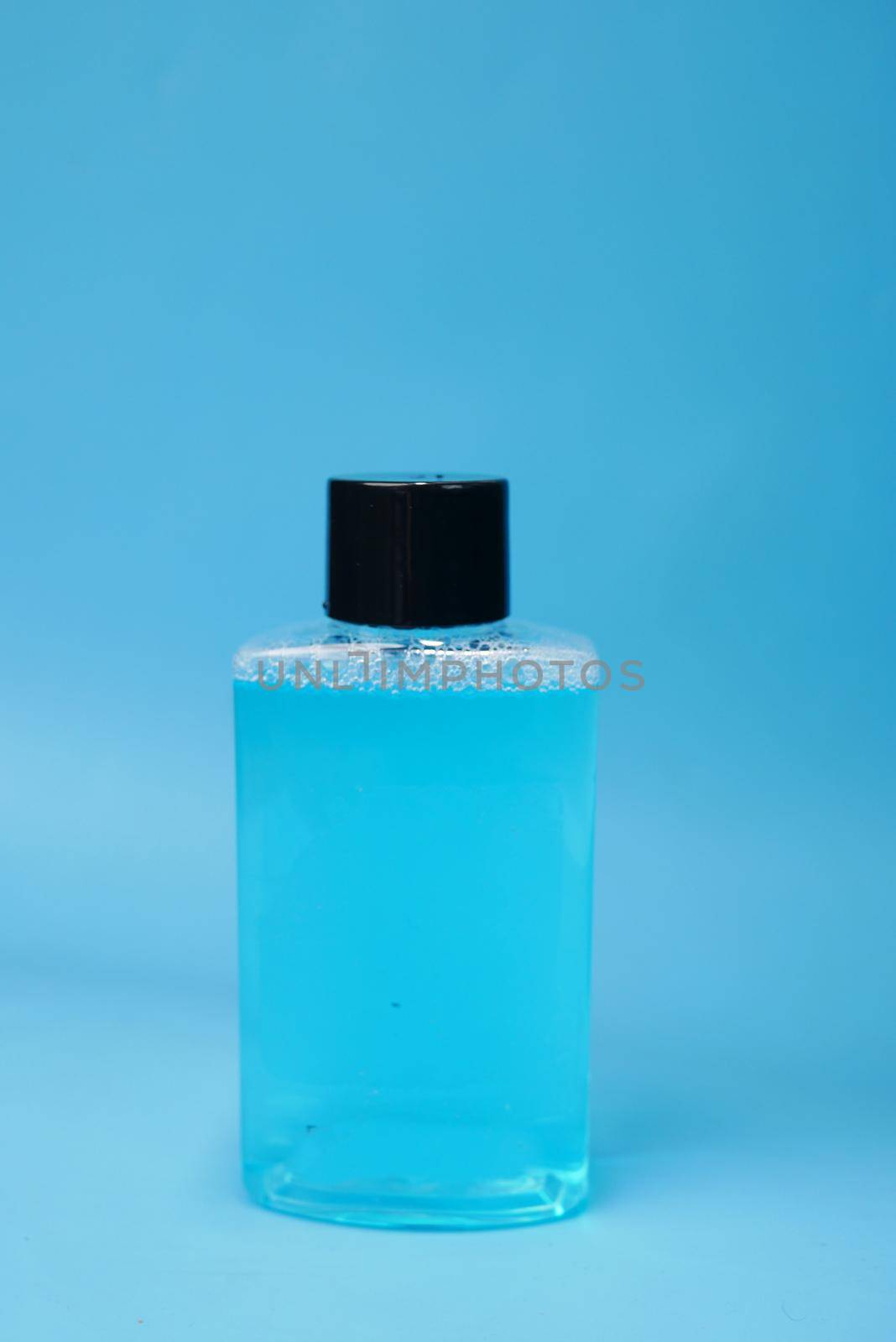 mouthwash liquid in a container on blue background by towfiq007