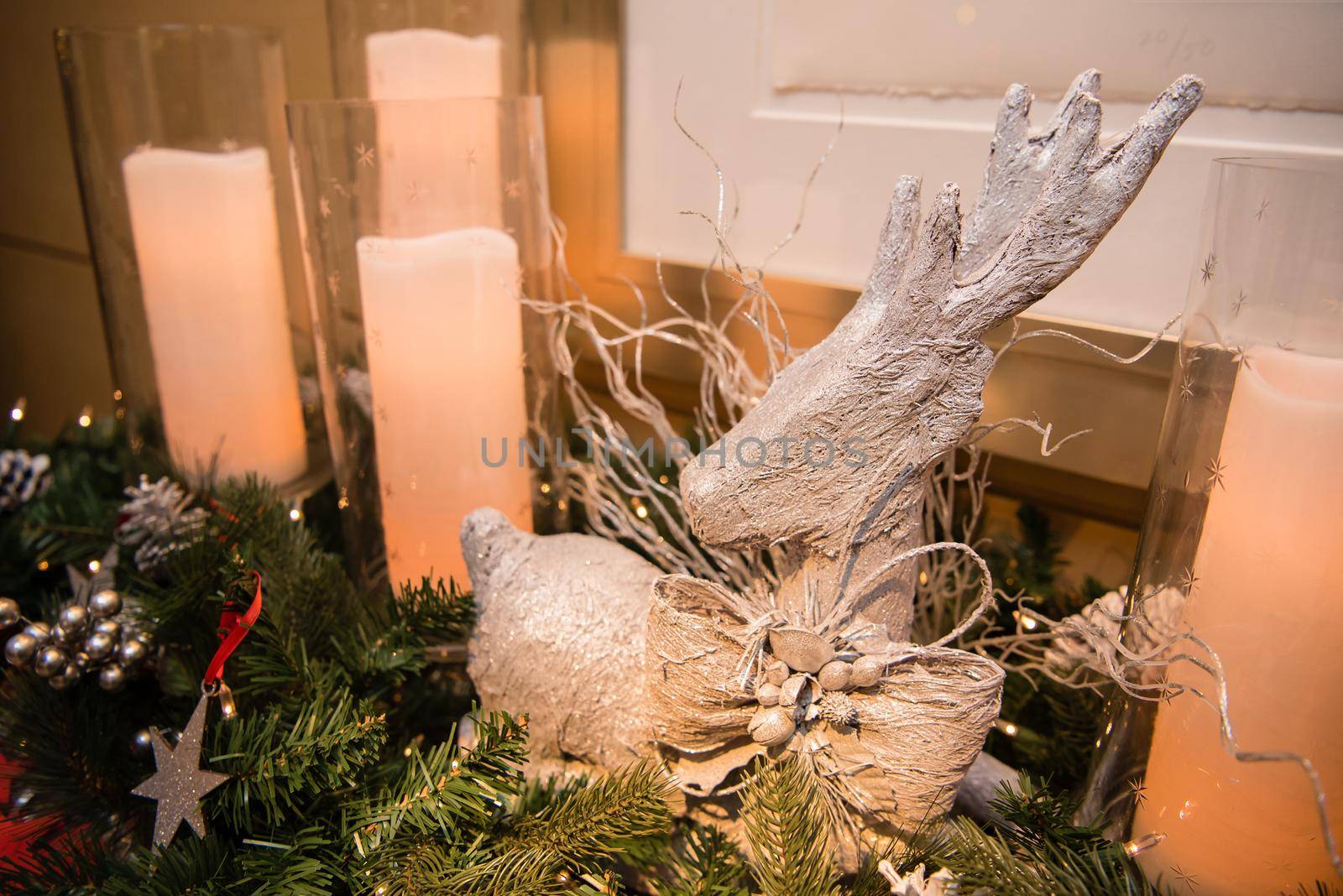 White reindeer decoration with candles and garland. by jyurinko