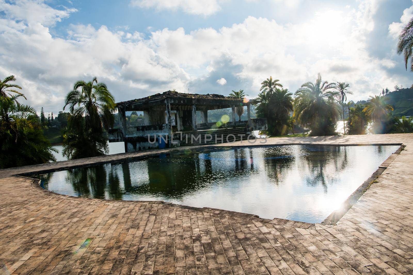 Guatape, Colombia - December 12, 2017: Pablo Escobar's old estate La Manuela in ruin with palm trees and reflection pool