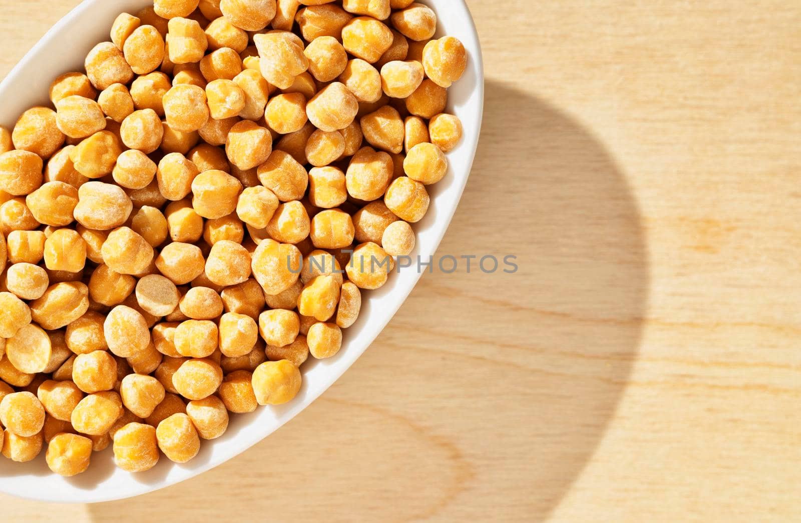 Dried chickpeas in white bowl on wooden background ,uncooked legume