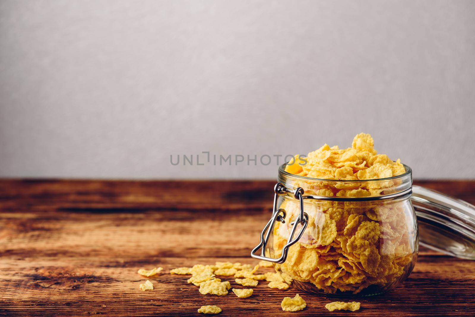 Corn flakes in a glass jar on wooden surface