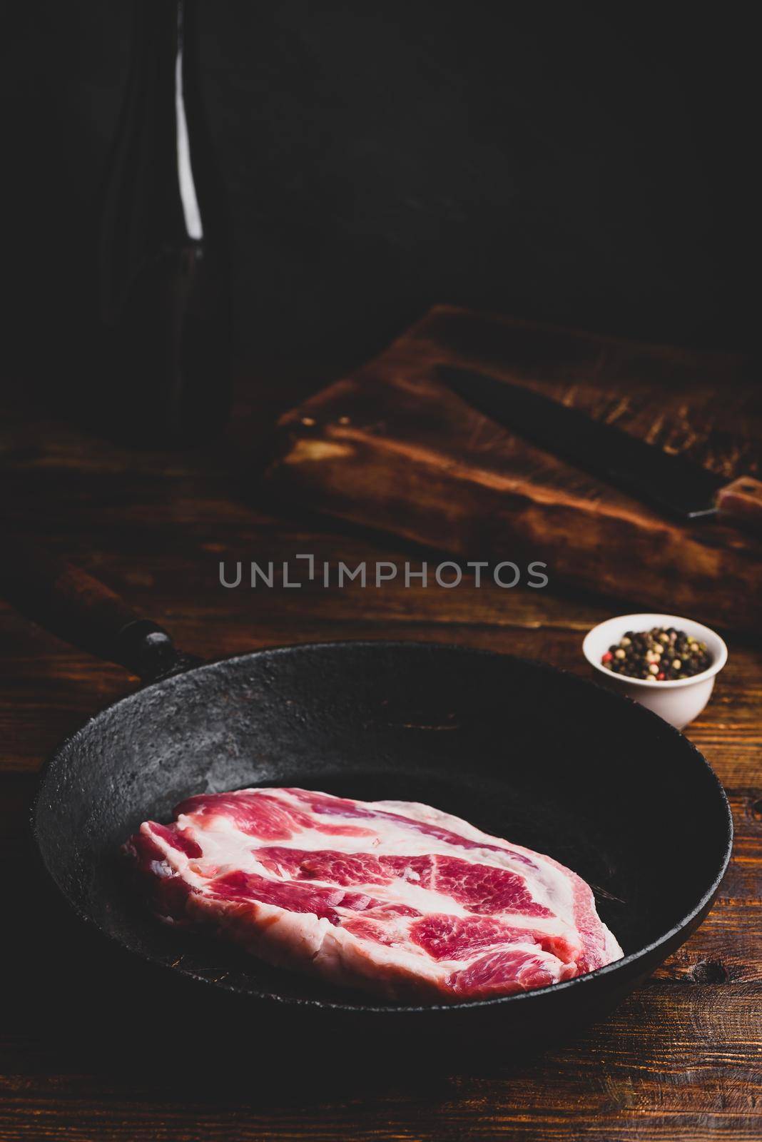 Raw pork neck steak in skillet by Seva_blsv