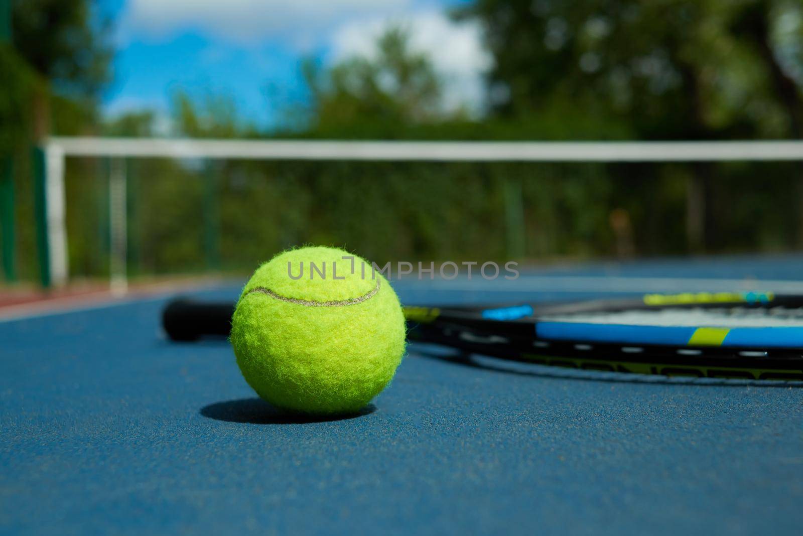 Close up of yellow ball on tennis racket background. by SerhiiBobyk