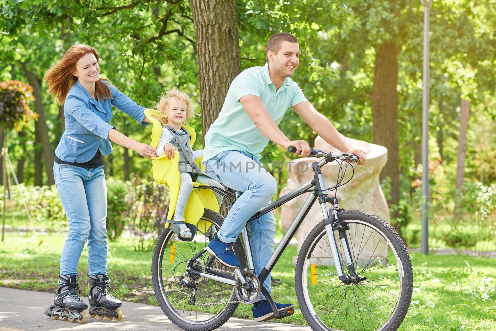 Happy family riding bike at the park by SerhiiBobyk
