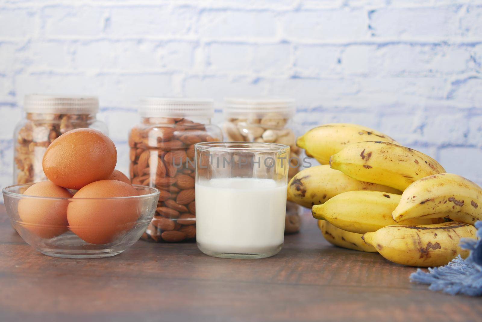 eggs in a plastic container, milk and almond nut in table ,