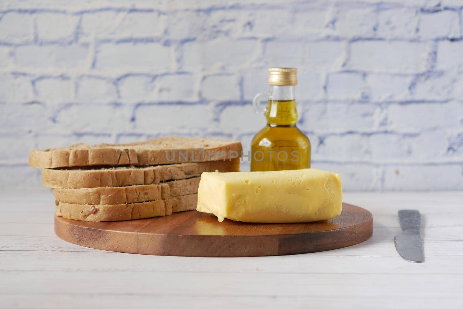 slice of butter and whole meal bread on chopping board .