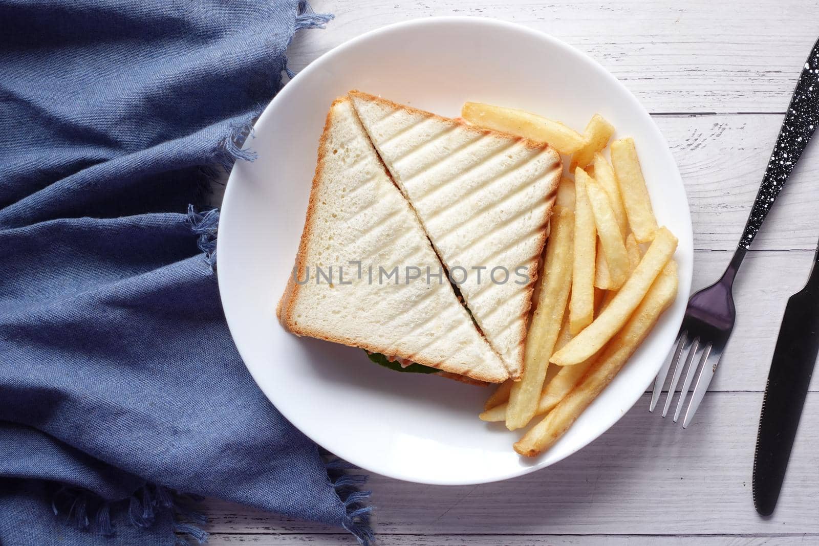 egg sandwich and chips on plate close up .