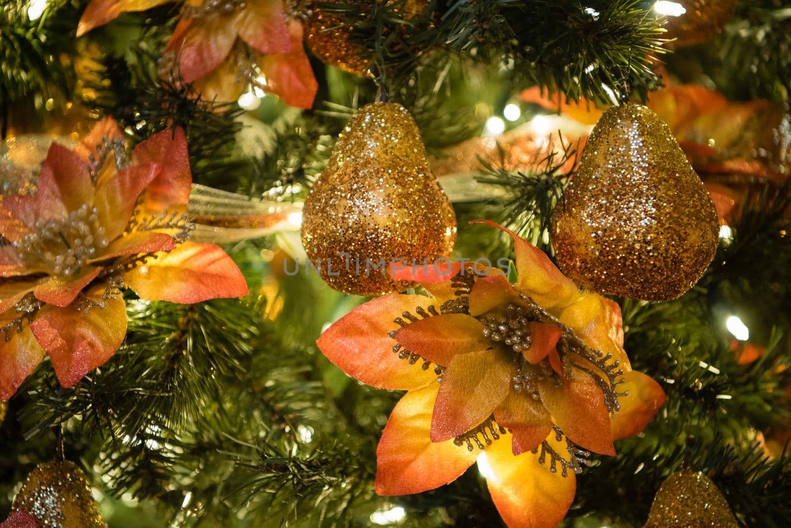 Christmas tree ornaments with gold sparkle and orange flowers. Close up by jyurinko