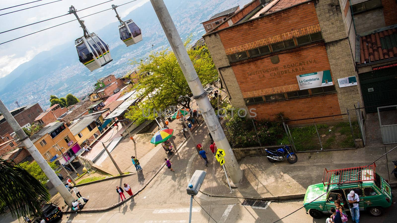 Cable cars in transit above houses in Medellin, Colombia. by jyurinko